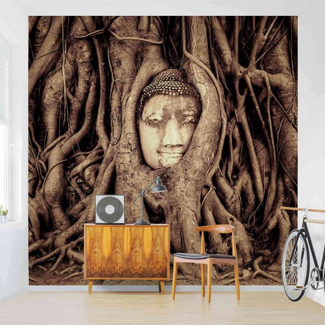 Wanddeko Wohnzimmer Buddha in Ayutthaya von Baumwurzeln gesäumt in Braun